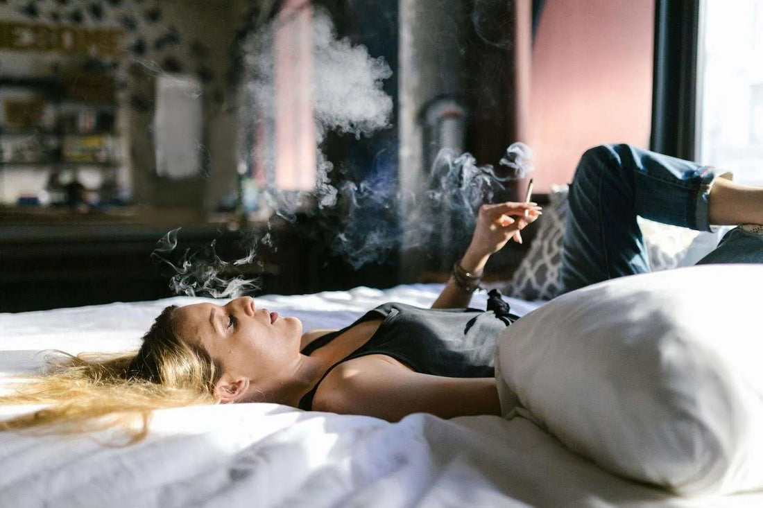 woman smoking thca hemp flower on her bed