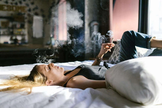 woman smoking thca hemp flower on her bed