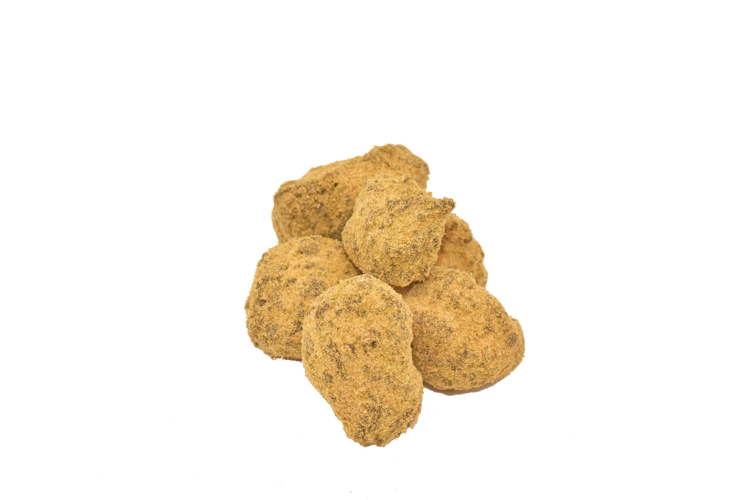 Small pile of moon rocks coated in kief on white background