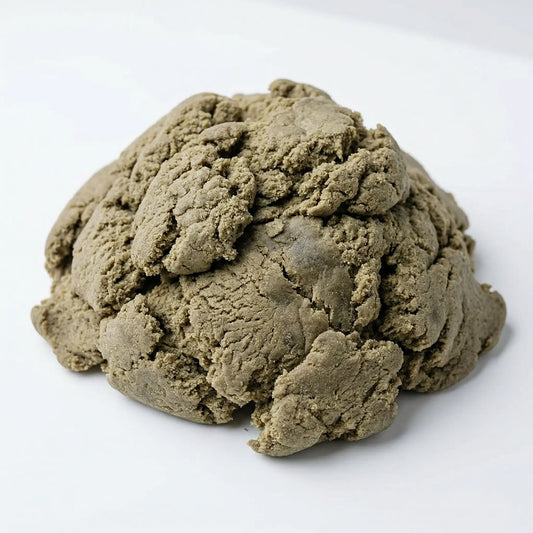 Large mound of loose THCA bubble hash on a white background, showing a rough textured surface with olive-brown and taupe tones