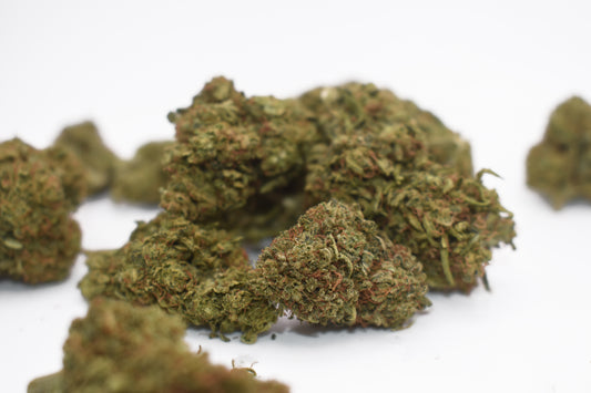 A fresh pile of Maui Wowie CBD + Delta-8 THC flower, showcasing dense, trichome-coated buds with a tropical pineapple-citrus aroma and balanced uplifting effects.
