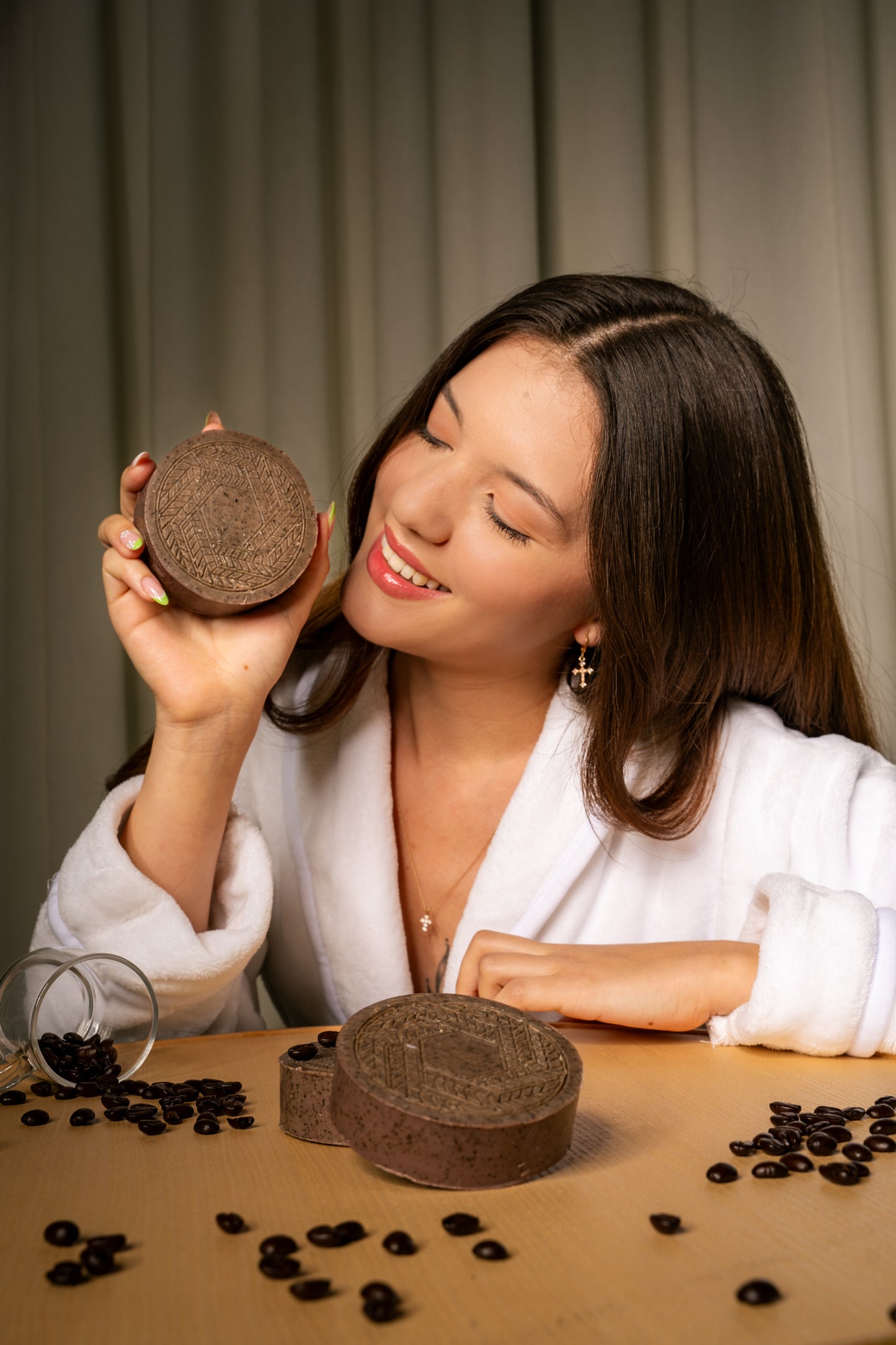 Young woman posing with a CBD soap bar infused with coffee, highlighting its antioxidant-rich formula for glowing, rejuvenated skin.