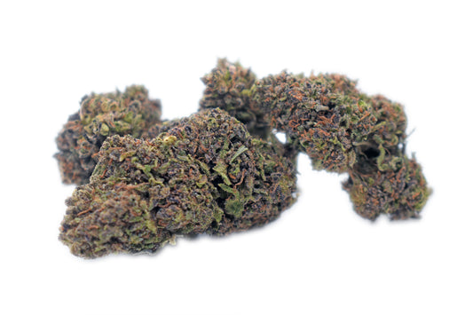 A fresh pile of Purple Gas CBD flower, featuring dense, trichome-coated buds with deep purple and green hues, emitting a strong gassy aroma and relaxing effects.