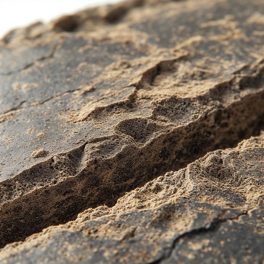 Dense, rectangular brick of Moroccan-style THCA hash with a dark, hand-pressed exterior and slightly porous interior texture