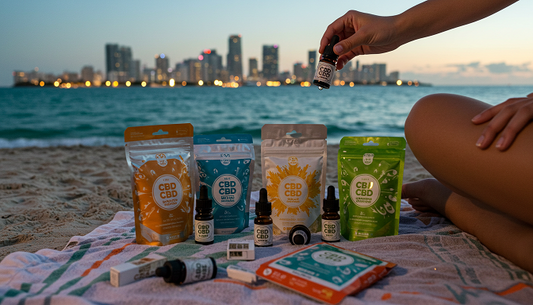 A person using CBD tincture on a Miami beach at dusk, with CBD products on a towel, ocean, and city skyline in the background.