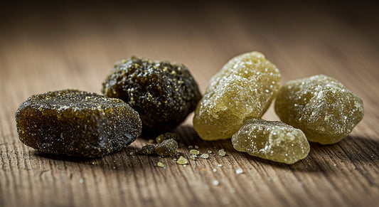A detailed shot of hash rocks and moon rocks placed on a rustic wooden table, emphasizing their unique textures, colors, and the differences between these cannabis concentrates.