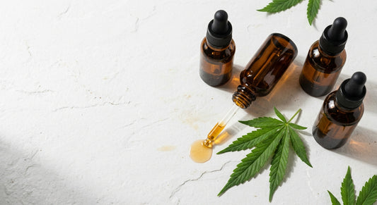 olio CBD in flaconi ambra con contagocce su superficie bianca guida 2026 Hurcann