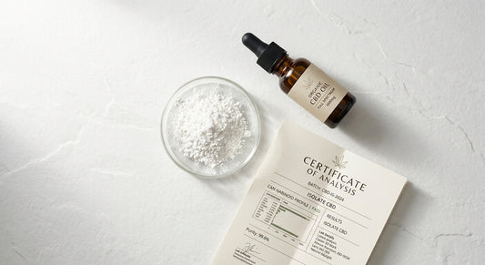 pure extract CBD isolate powder in glass dish with COA document on white surface
