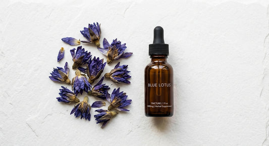 blue lotus extract tincture bottle alongside dried Nymphaea caerulea flowers flat lay