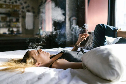 woman smoking thca hemp flower on her bed 