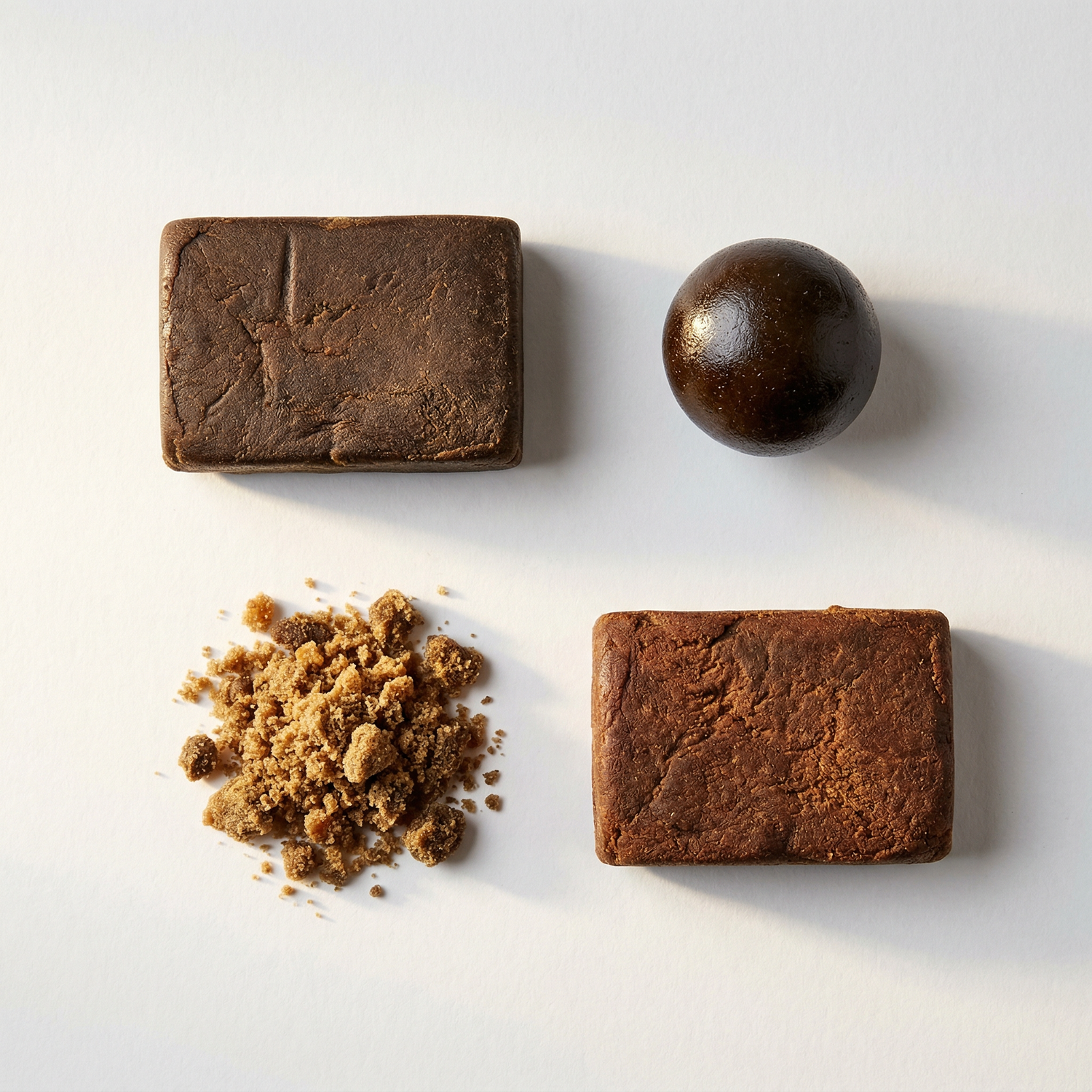 Multiple varieties of premium pressed hash blocks displayed on dark slate surface for wholesale sourcing