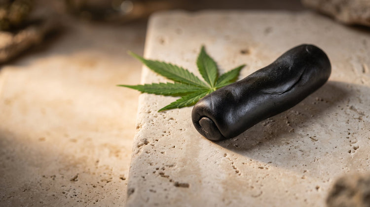 Pliable black hash with a hemp leaf on stone