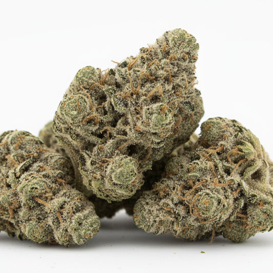 Mitten Cake Badder buds are dense, with dark green tones and amber pistils covered in a thick trichome coating that glistens under light