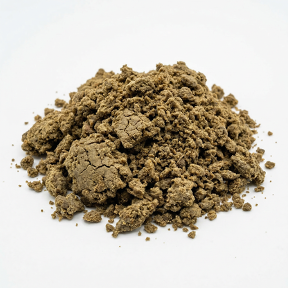 Large loose mound of crumbled CBD bubble hash on a white background, warm olive-brown granular texture with varied chunk sizes scattered around the base