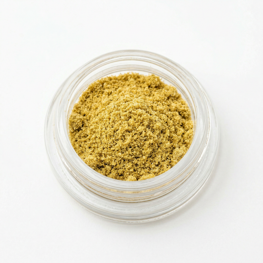 CBD kief in an open glass jar on white background — golden hemp-derived dry-sift CBD kief powder