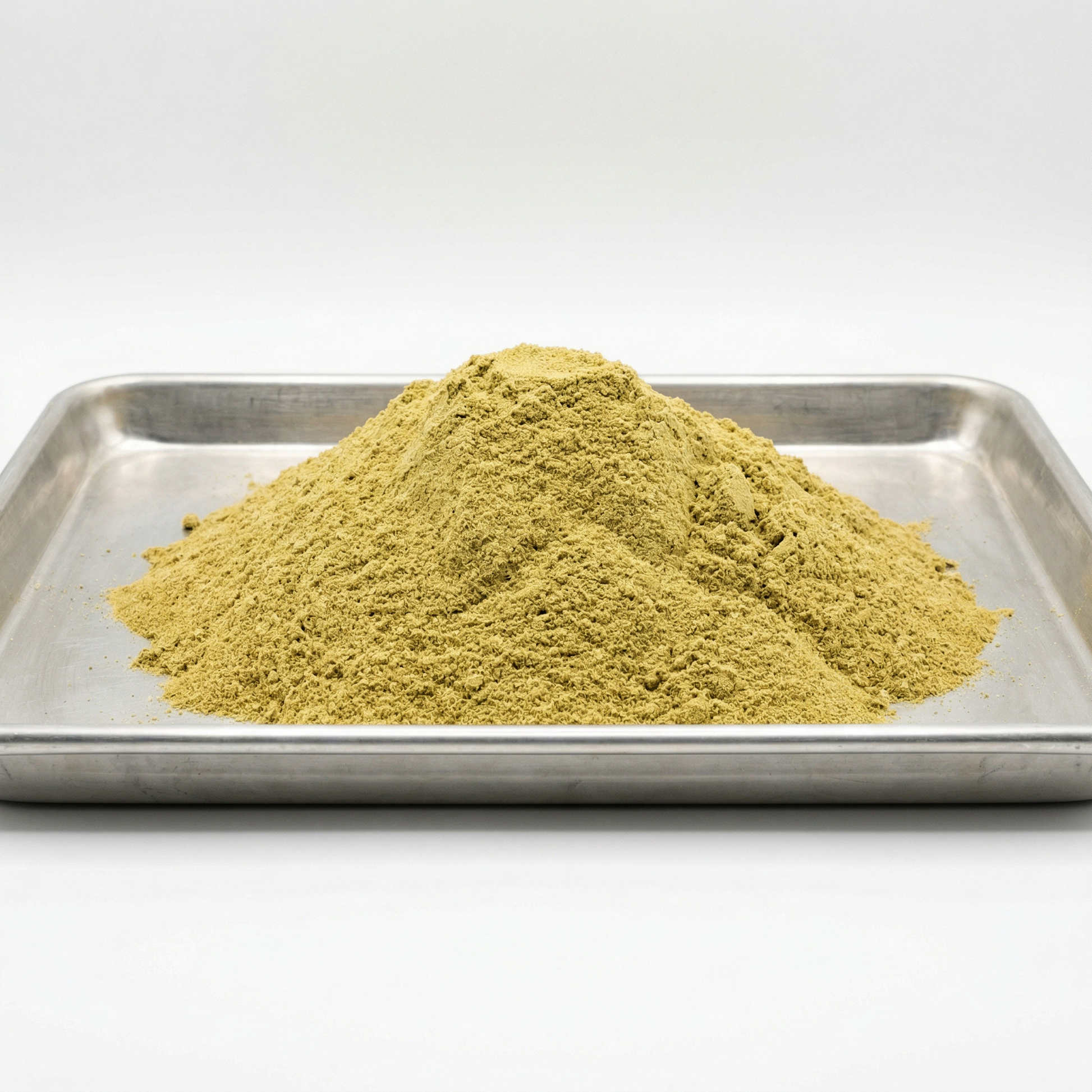 Bulk CBD kief powder mounded on a stainless steel tray — wholesale hemp-derived CBD kief, white background