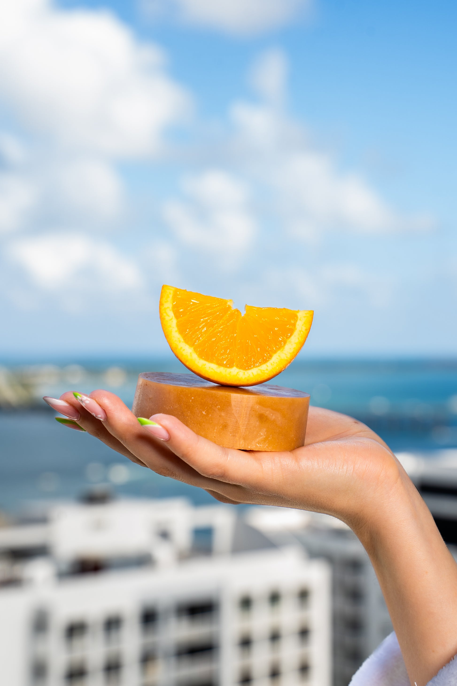 CBD-infused soap bar with a fresh orange placed on top, highlighting its citrus essential oils, nourishing botanicals, and refreshing scent.