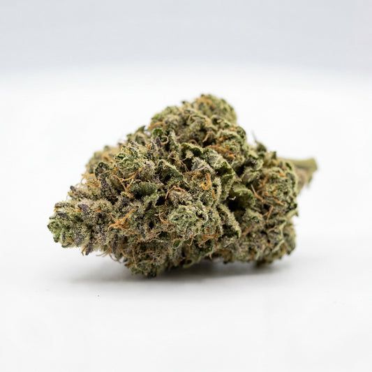 Single premium Gelato CBD hemp flower bud photographed against a clean studio background.
The bud displays a dense calyx structure with green and purple tones and visible trichome coverage.