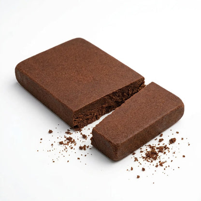 Bulk wholesale CBD Lebanese red hash slab broken into a large piece and a small piece on a white background | Hurcann