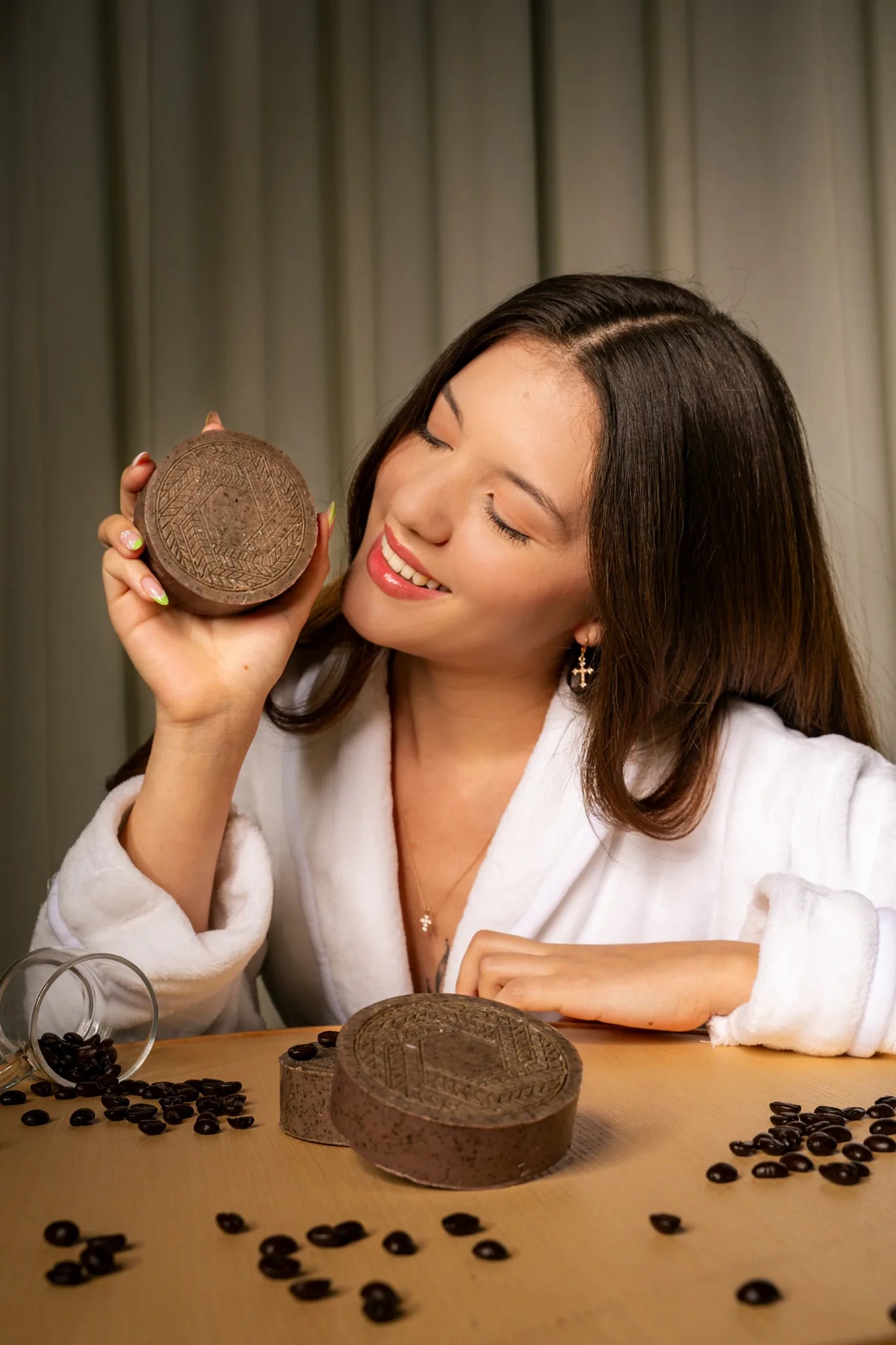 Young woman posing with a CBD soap bar infused with coffee, highlighting its antioxidant-rich formula for glowing, rejuvenated skin | Hurcann