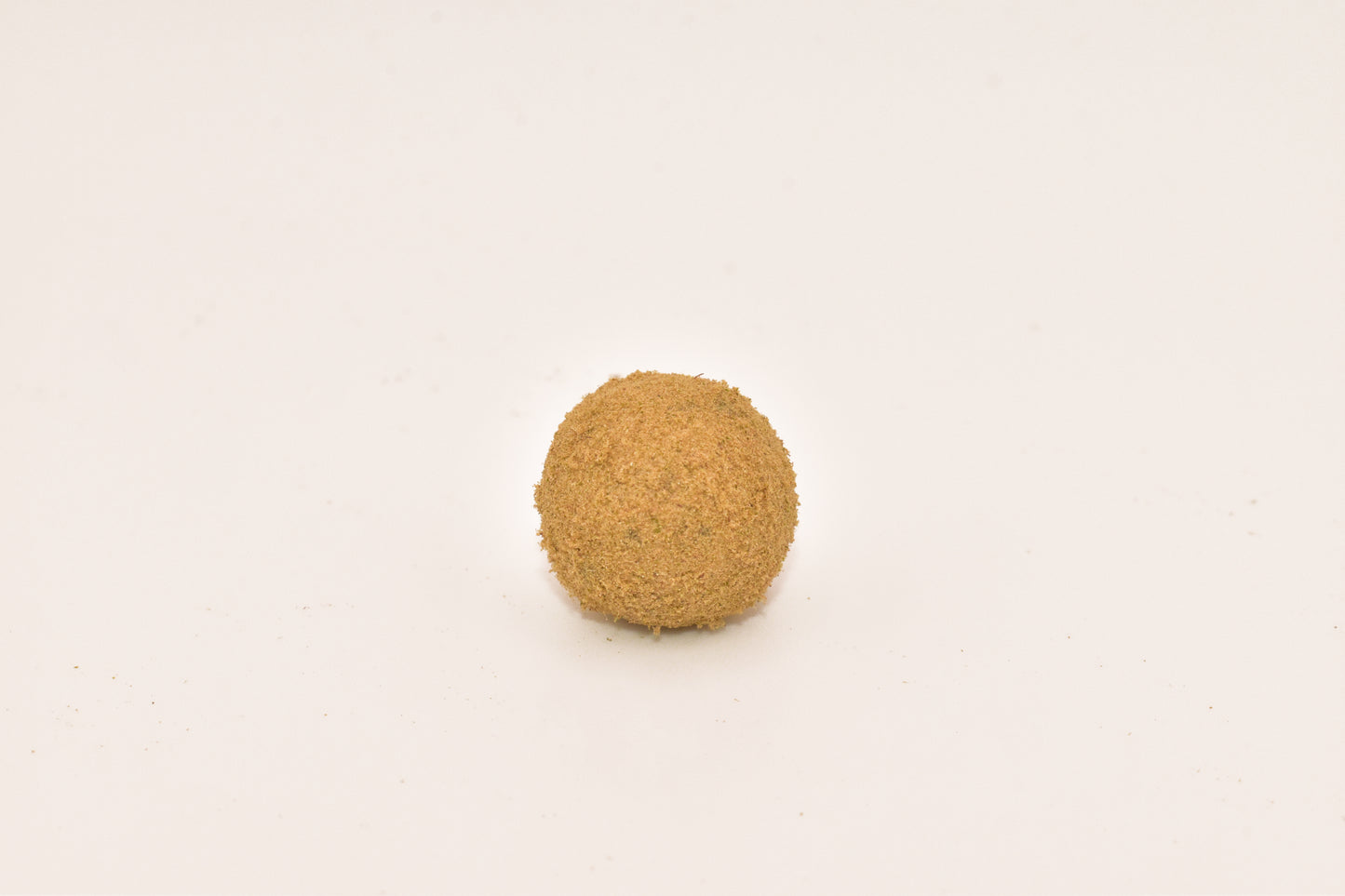 Close-up of a Hurcann THCa Hash Rock, showcasing a dense cannabis nug infused with high-THCa distillate and coated in a thick layer of kief for maximum potency and a smooth, flavorful smoke.