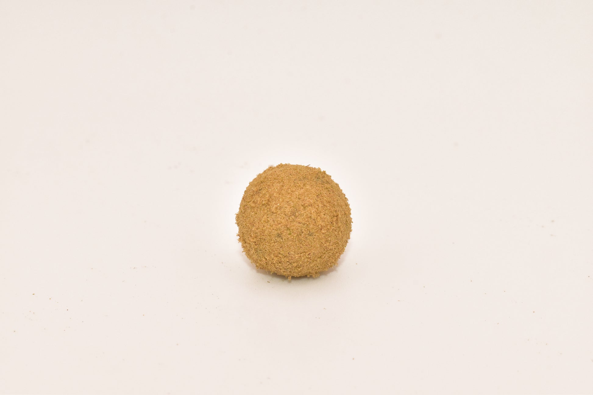 Close-up of a Hurcann THCa Hash Rock, showcasing a dense cannabis nug infused with high-THCa distillate and coated in a thick layer of kief for maximum potency and a smooth, flavorful smoke.