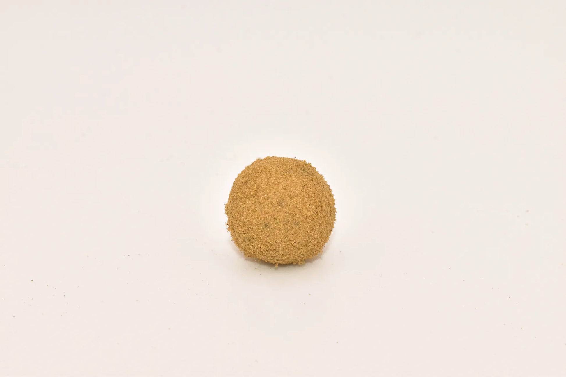 Close-up of a Hurcann THCa Hash Rock, showcasing a dense cannabis nug infused with high-THCa distillate and coated in a thick layer of kief for maximum potency and a smooth, flavorful smoke.