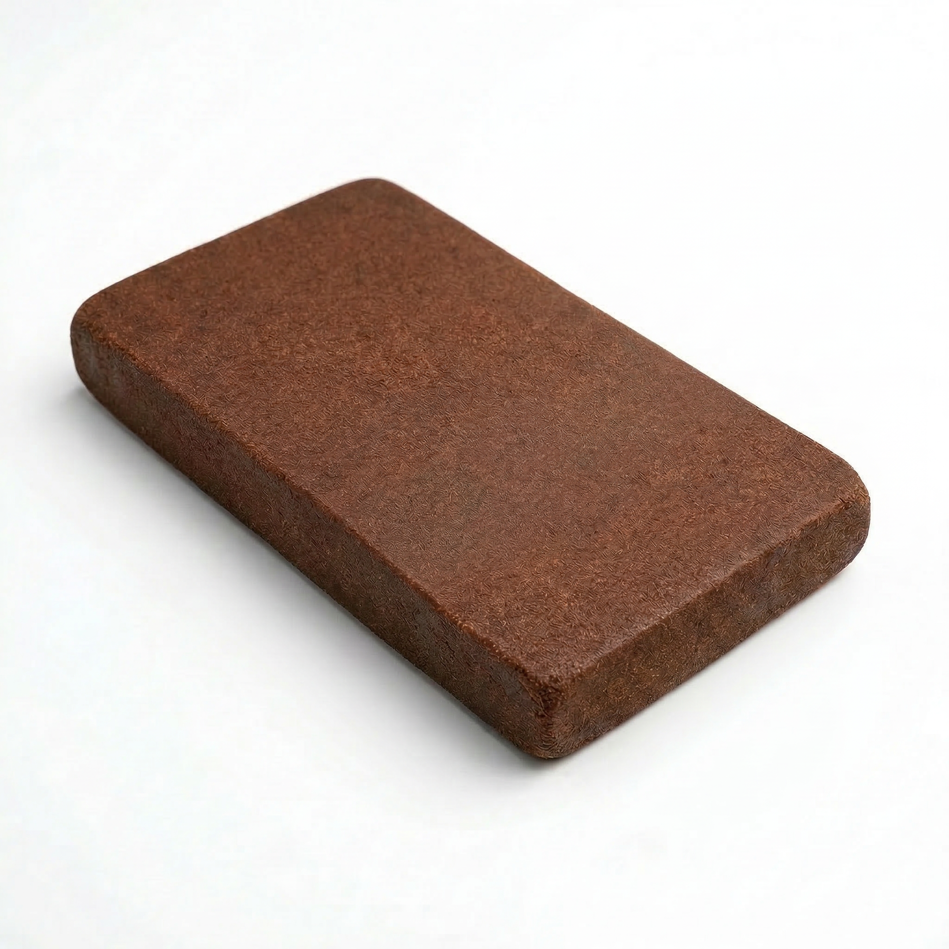 Single THCA Lebanese red hash slab lying flat on a white surface, rich chocolate-brown color with a smooth matte fibrous surface texture and clean slightly rounded corners