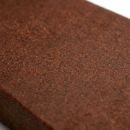 Extreme close-up of bulk wholesale THCA Lebanese red hash slab surface showing fine fibrous granular texture in rich reddish-brown and chocolate tones, shallow depth of field with sharp center focus — wholesale THCA hash concentrate surface detail