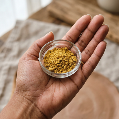 Hand holding a small glass dish of golden THCA kief powder — hemp-derived dry-sift kief 1/4 oz
